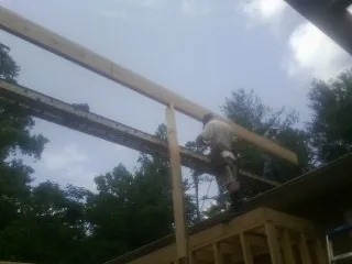 Carpenter setting a ridge beam over a new addition frame — Ice Dam Removal by Roofing Brothers in Carmel