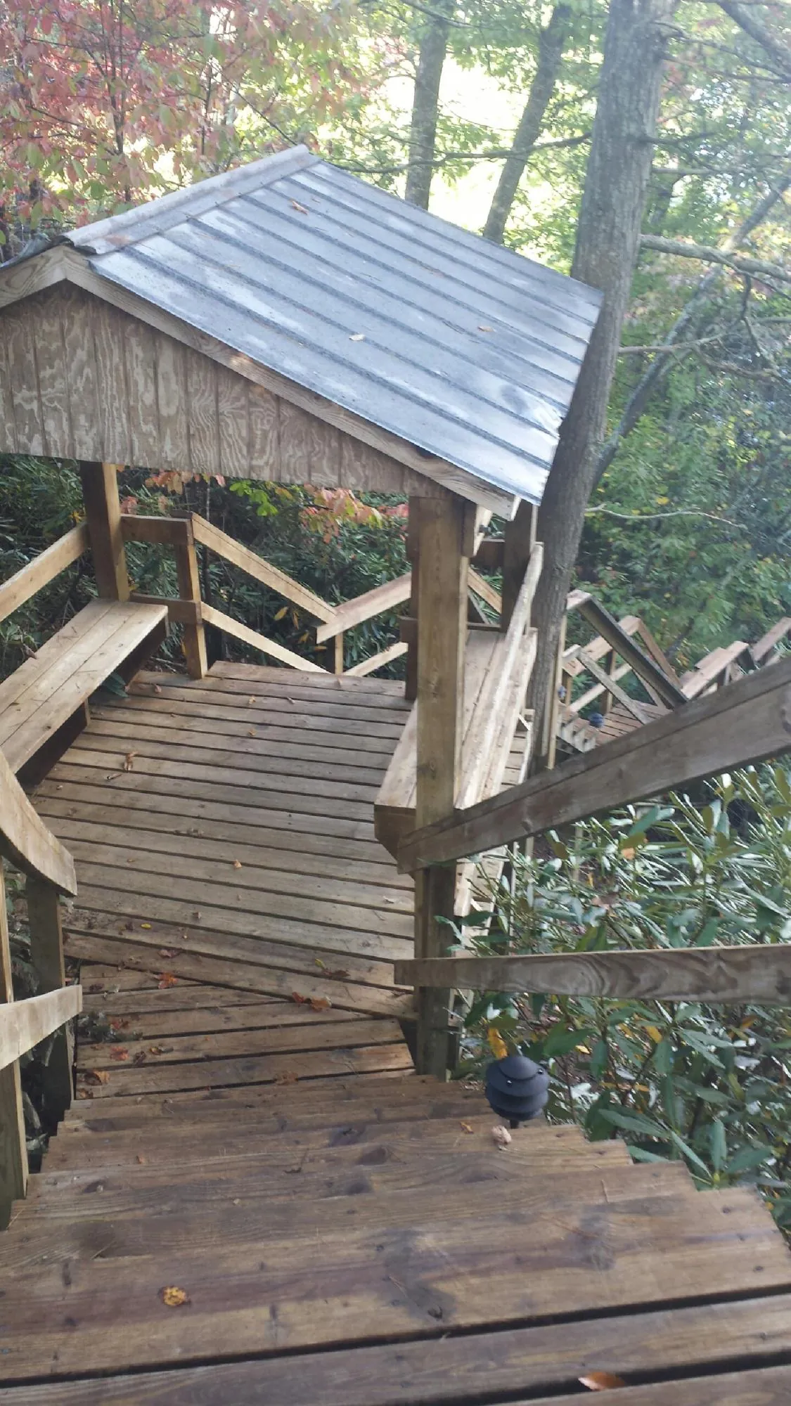 Metal roofed shelter over wooden steps on a wooded walkway — Skylight Repair & Installation work by our crew in Carmel